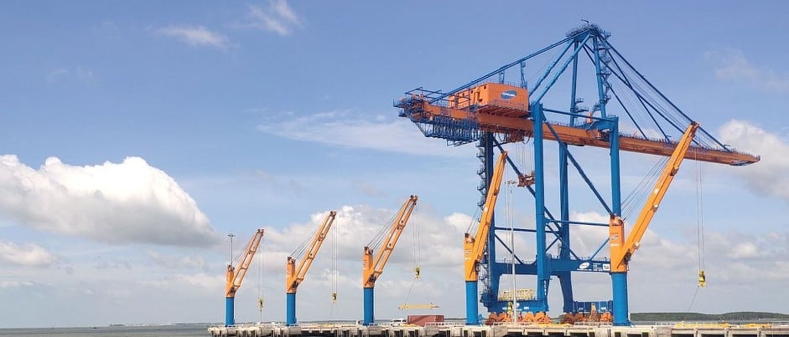 A geared general cargo vessel working alongside a quay.